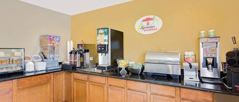 A breakfast bar with various food and drink dispensers, including a coffee machine, a juice dispenser, and a cereal dispenser.