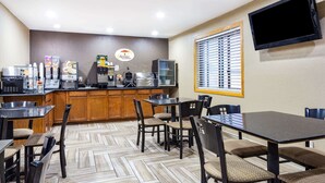 A breakfast area with a coffee machine, a refrigerator, and a menu board. - Super 8 by Wyndham Decorah (Decorah)