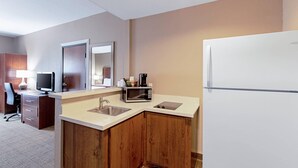 Cocina de hotel compacta con microondas, cafetera y refrigerador.