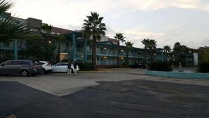 A motel with multiple floors, a parking lot, and palm trees. -  Stay Express Inn Near Downtown San Antonio TX (San Antonio)