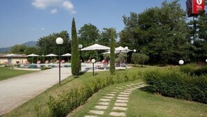 A resort with a pool, lounge chairs, and umbrellas.