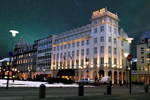 Un hotel con varios pisos, amplias ventanas y un cartel llamativo en la parte superior.