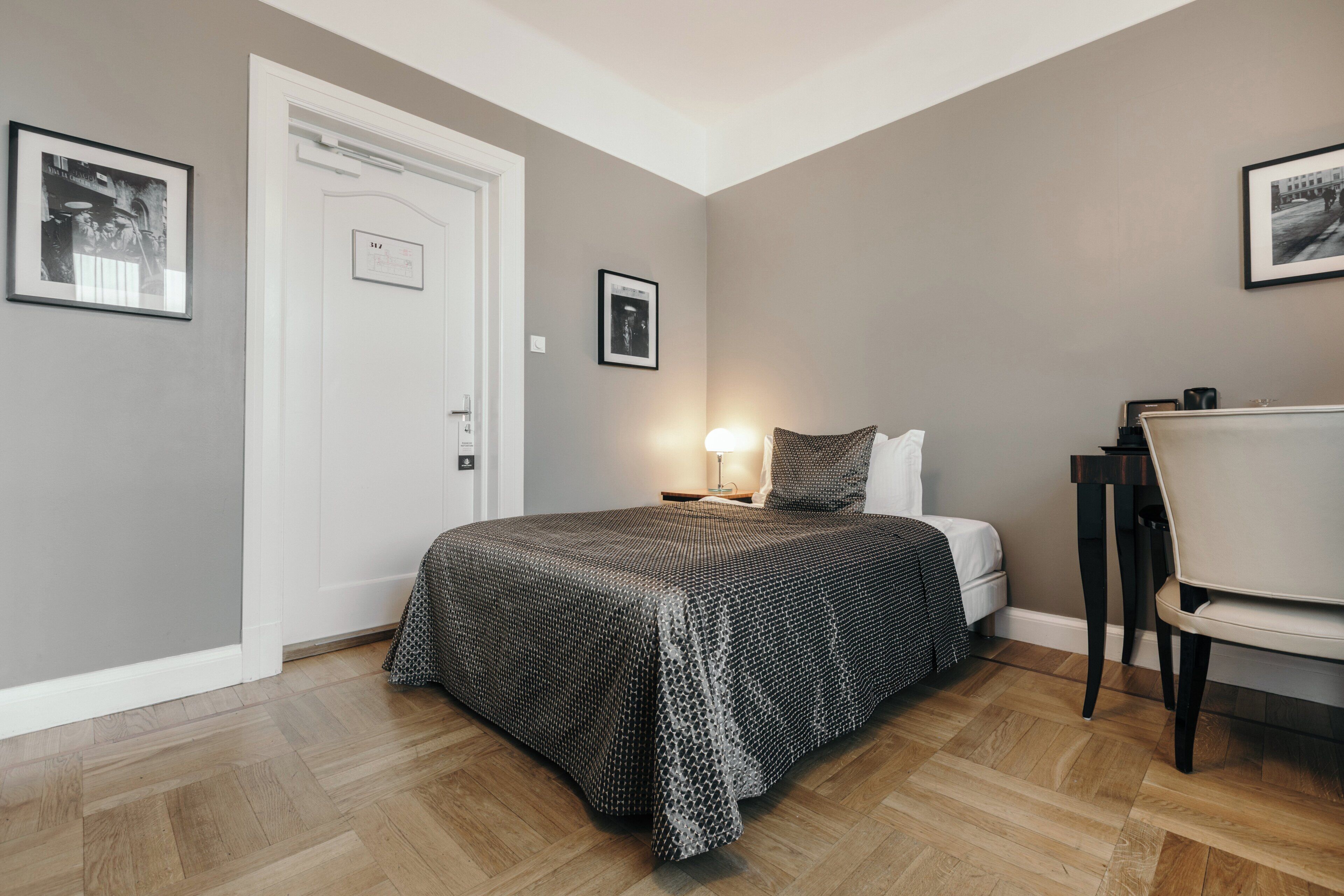 A bedroom with a bed, bedside lamp, and a chair.