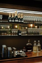 Zona de bar con botellas de champán Bollinger y una variedad de copas.