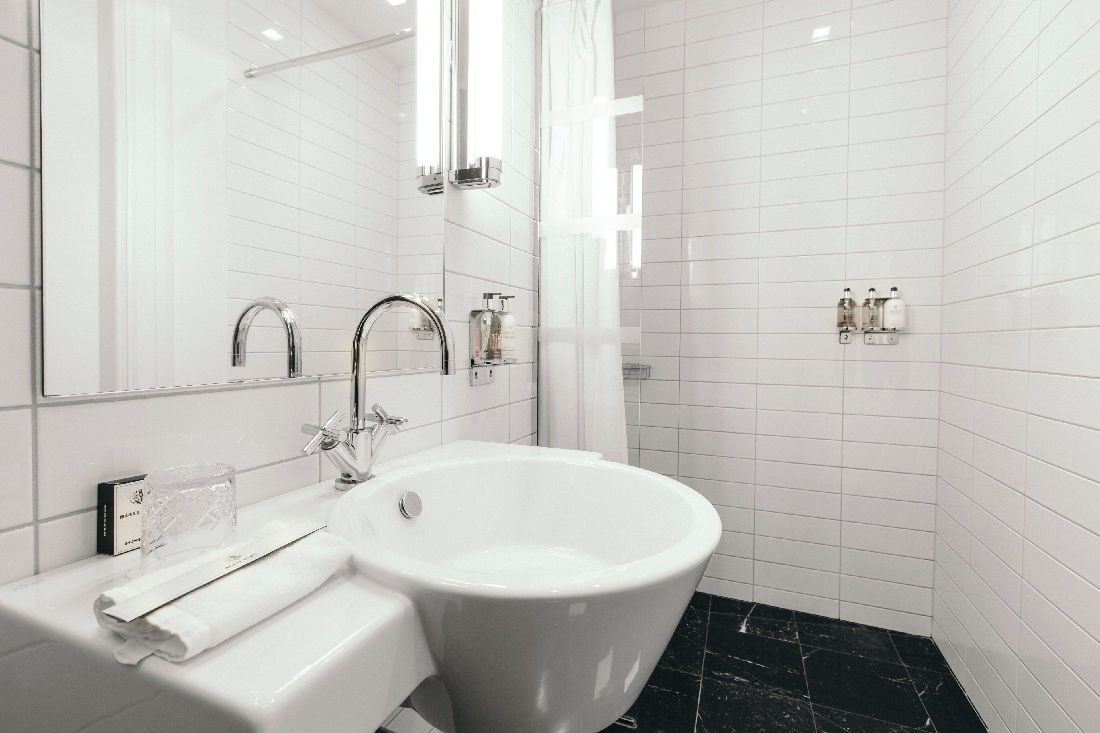 Un bany modern amb un lavabo blanc, una banyera gran i una zona de dutxa.