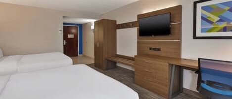 Habitación de hotel con cama, escritorio, silla, televisor y armario.