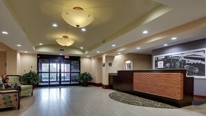 A hotel lobby with a reception desk, seating area, and large windows. - Hampton Inn & Suites Spartanburg-I-26-Westgate Mall (Spartanburg)