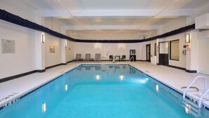 A large indoor swimming pool with clear water, surrounded by lounge chairs and tables, and equipped with safety signage. - Hampton Inn & Suites Spartanburg-I-26-Westgate Mall (Spartanburg)