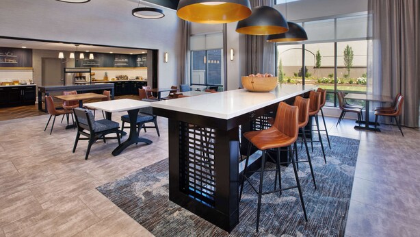 A modern kitchen with a central island, bar stools, and pendant lighting. - Hampton Inn & Suites Spartanburg-I-26-Westgate Mall (Spartanburg)