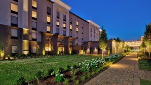 A modern hotel with a well-maintained lawn, brick pathway, and a row of white flowers. - Hampton Inn & Suites Spartanburg-I-26-Westgate Mall (Spartanburg)