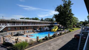 Una piscina al aire libre de temporada, sombrillas