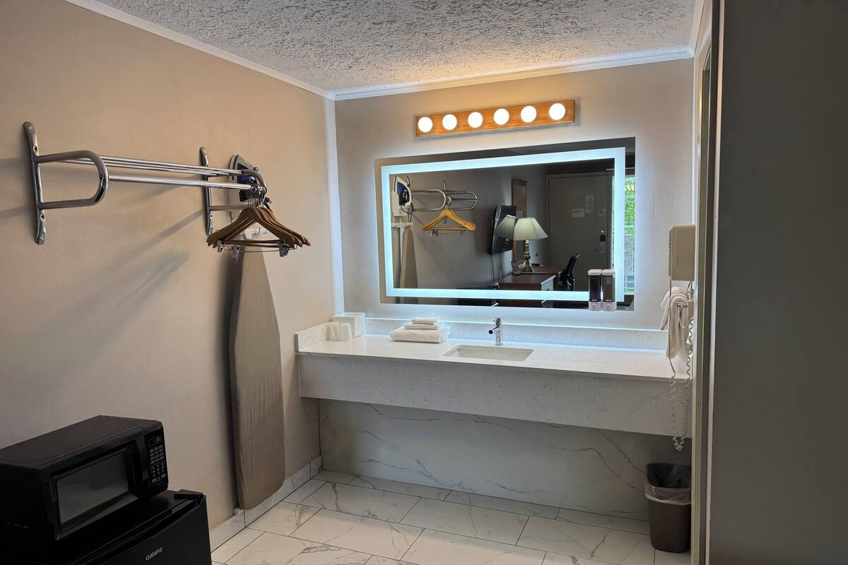 deluxe double room, 2 queen beds, refrigerator & microwave | bathroom sink