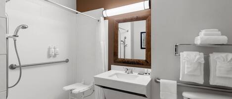Un baño moderno con ducha, lavamanos e inodoro.