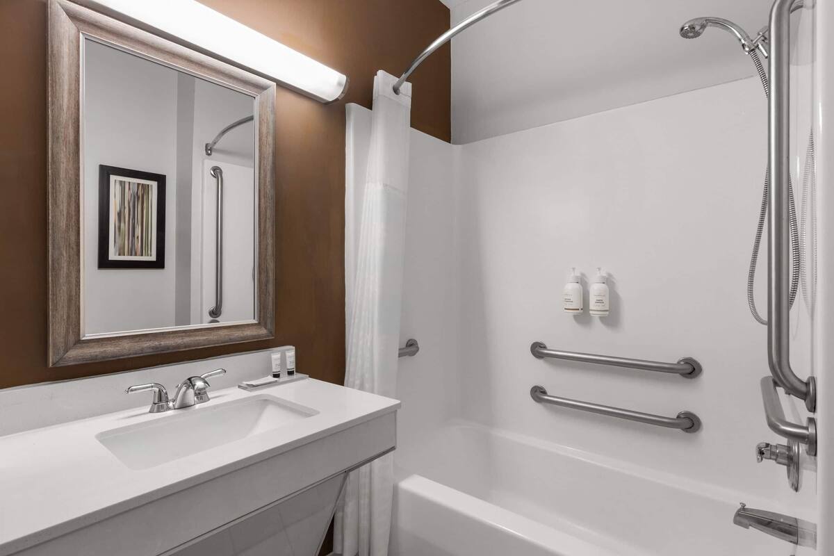 Une salle de bain moderne avec un lavabo blanc, un miroir et une douche.