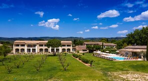 Um resort com várias villas, uma piscina e um gramado bem cuidado.
