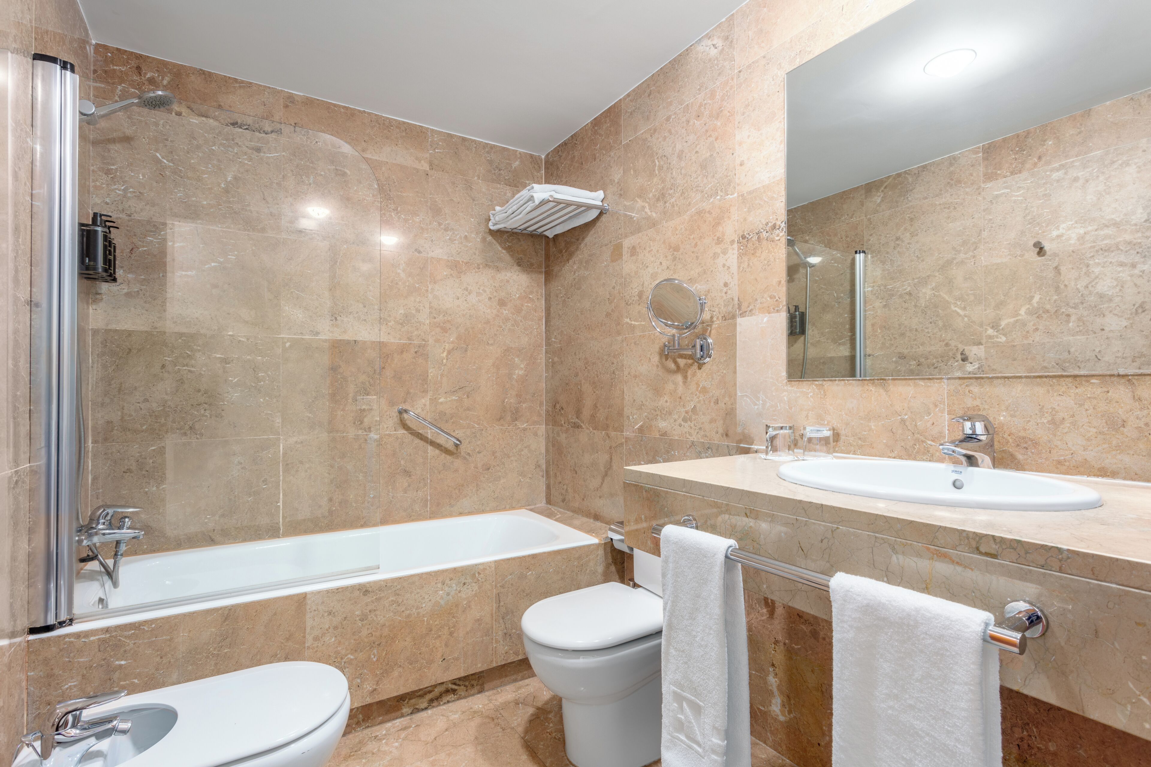 Une salle de bain avec une baignoire, des toilettes et deux lavabos.