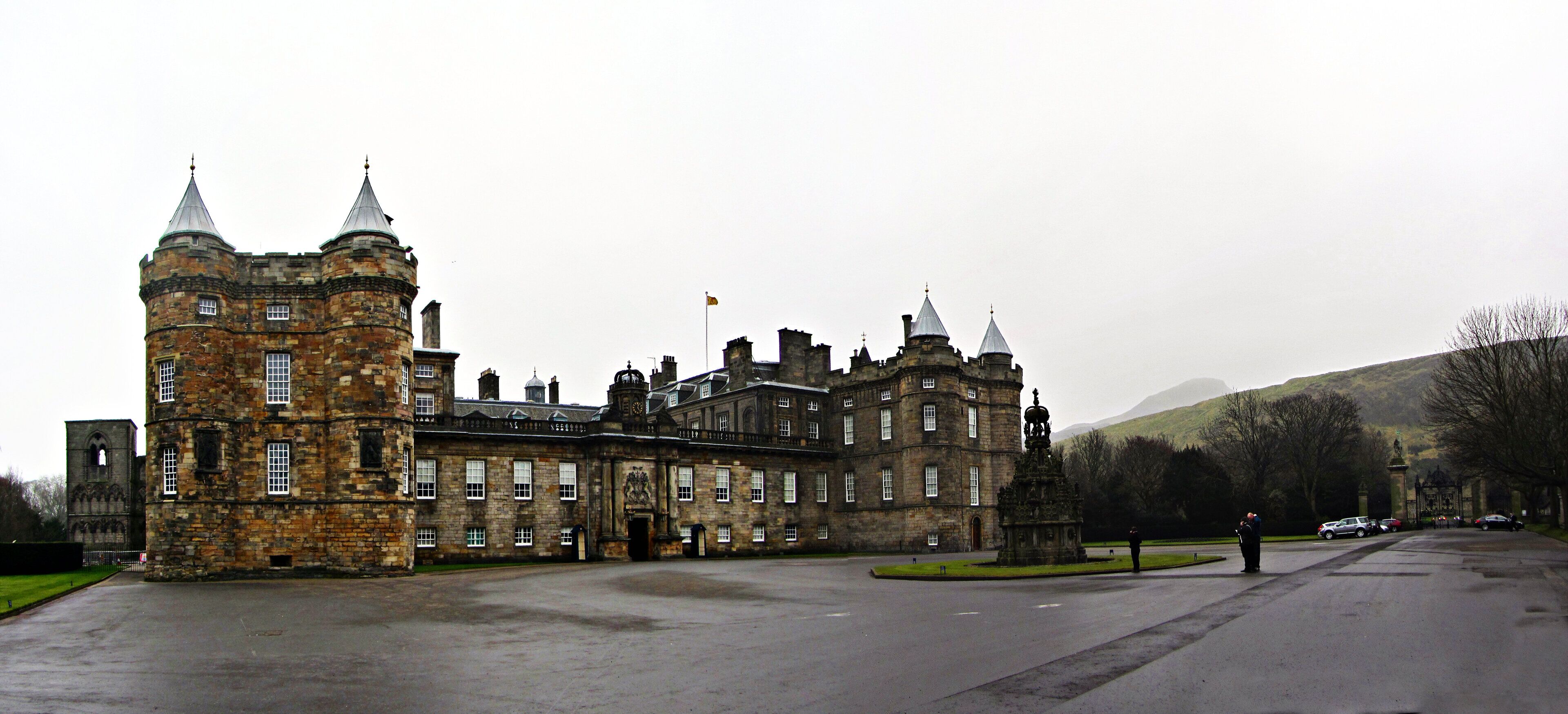 A historic stone building with multiple towers and a large courtyard.