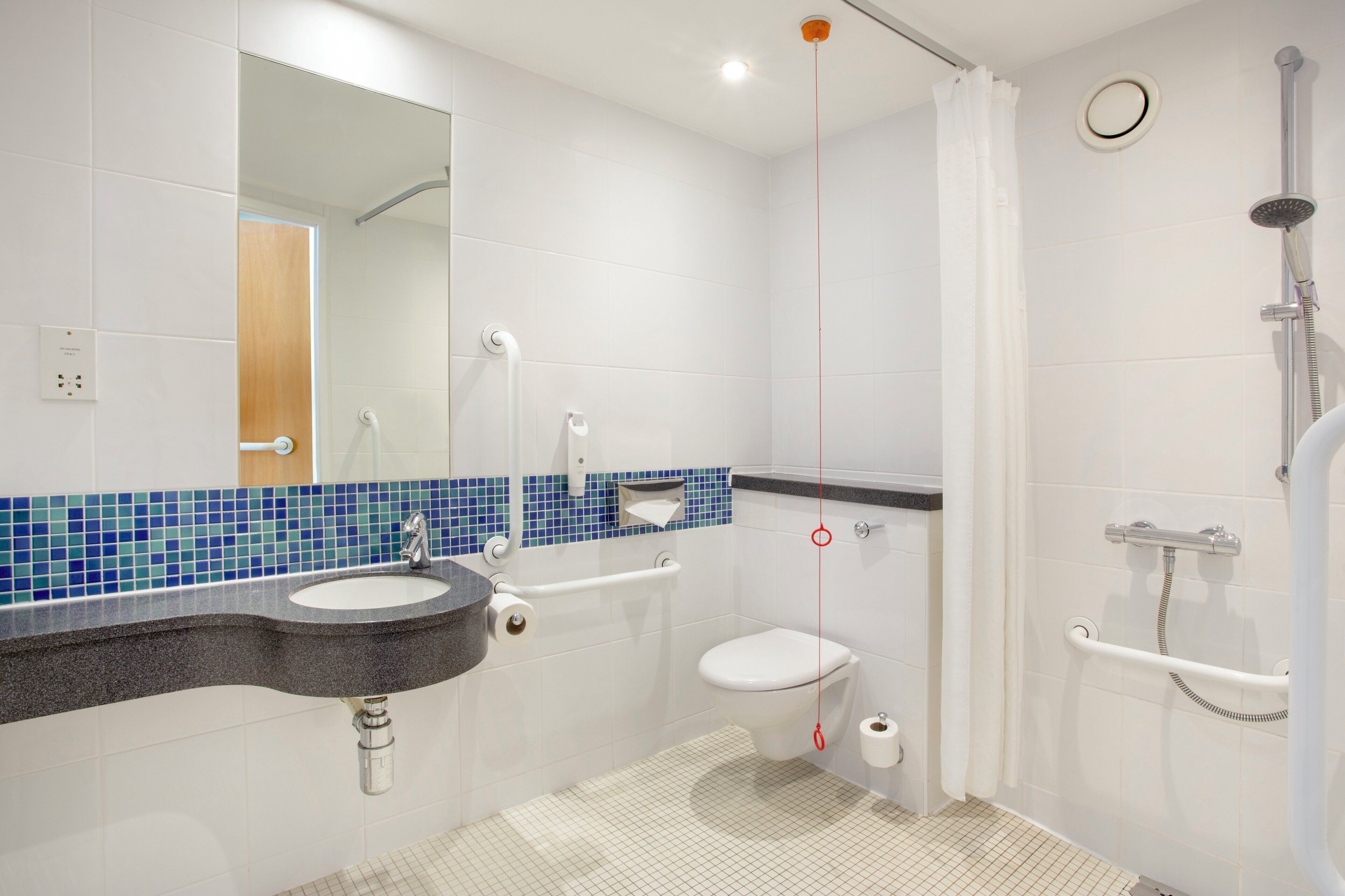 A modern bathroom with a sink, toilet, and shower.