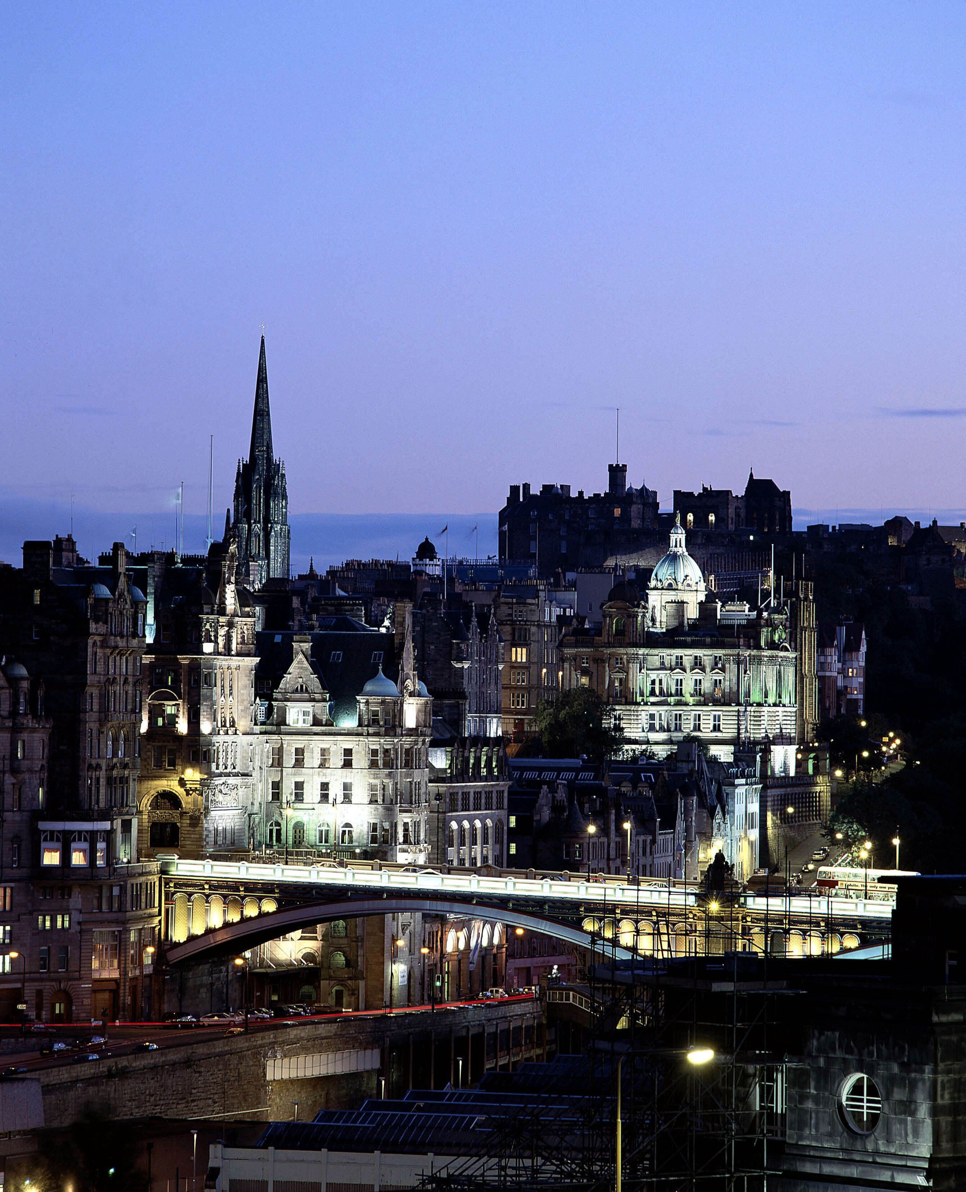 Un paisaje urbano con edificios históricos, una catedral destacada y un puente.