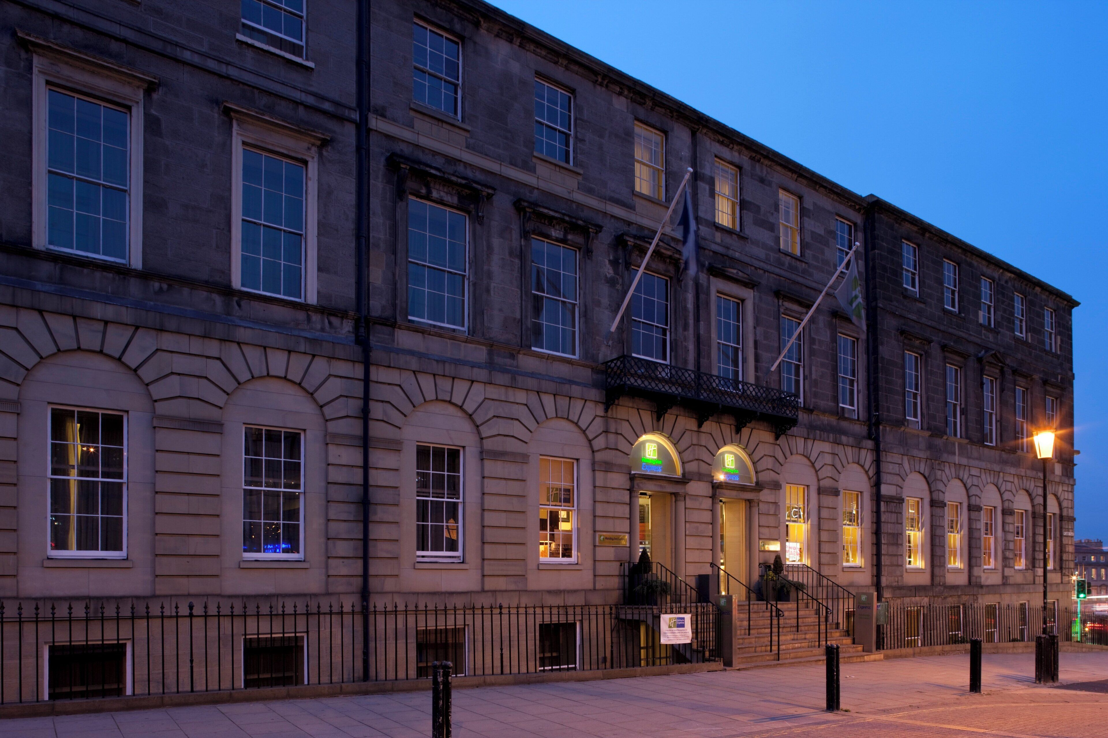 A historic building with multiple windows and a flagpole.
