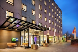 A hotel with a glass entrance, outdoor seating, and a Holiday Inn Express sign. - Holiday Inn Express Düsseldorf City North by IHG (Düsseldorf)