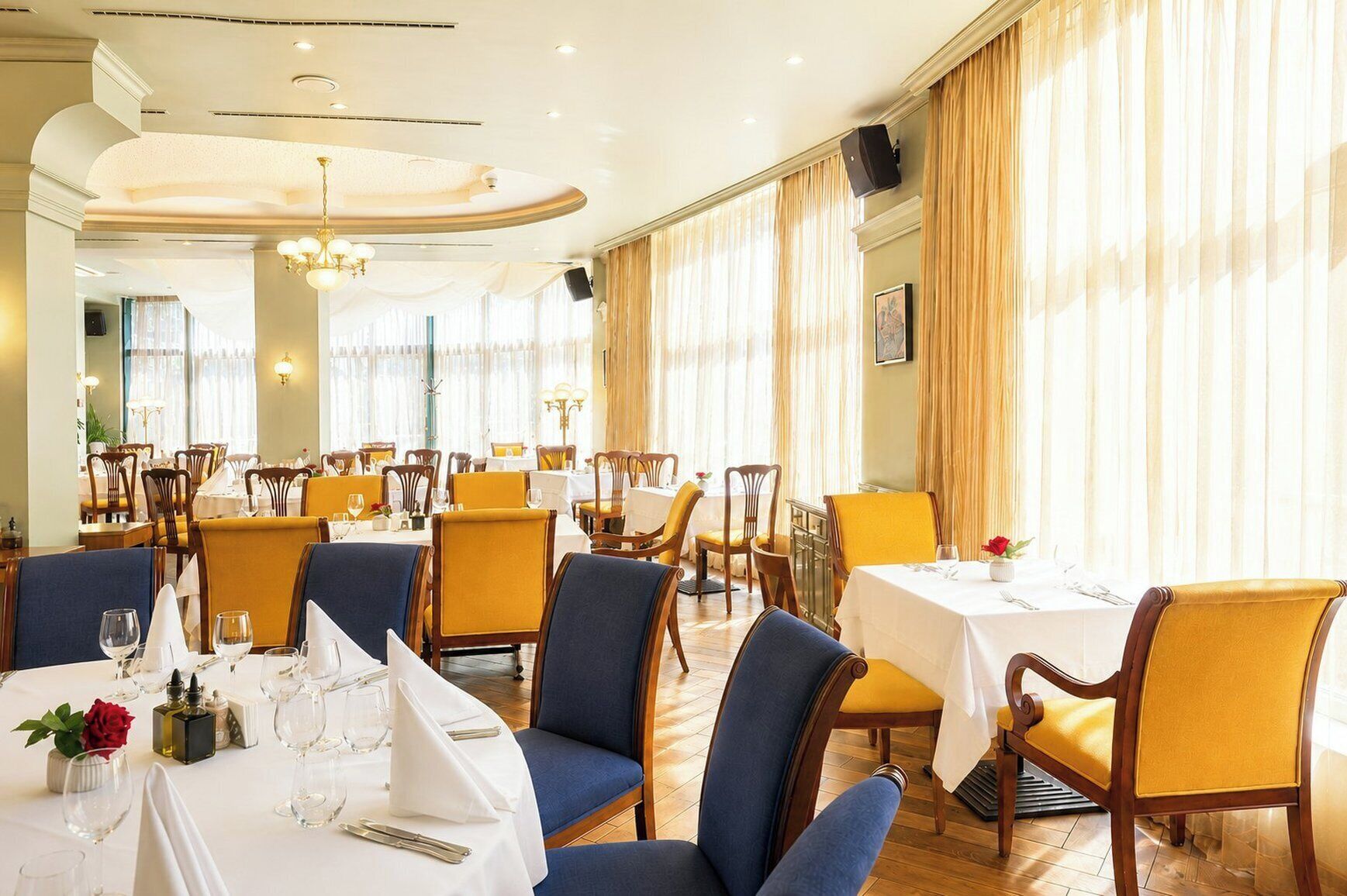 Un restaurant amb diverses taules, cadieres i un candelabrum.