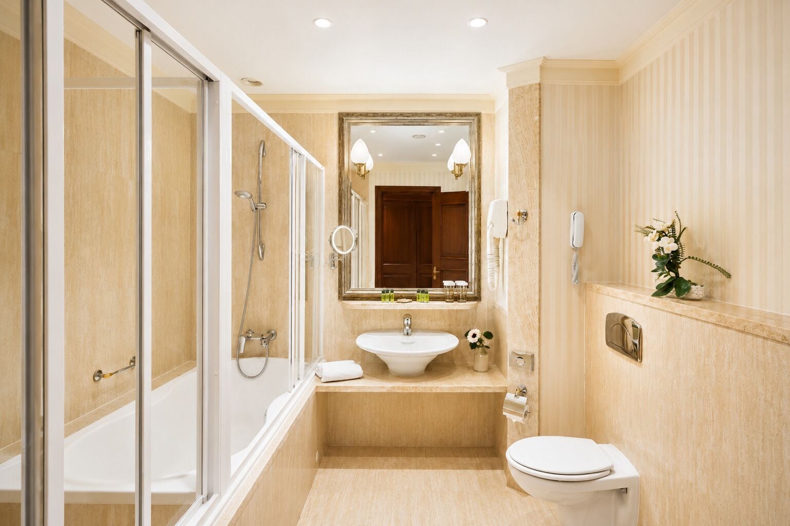 Une salle de bain avec une douche à parois de verre, un lavabo, des toilettes et un miroir.
