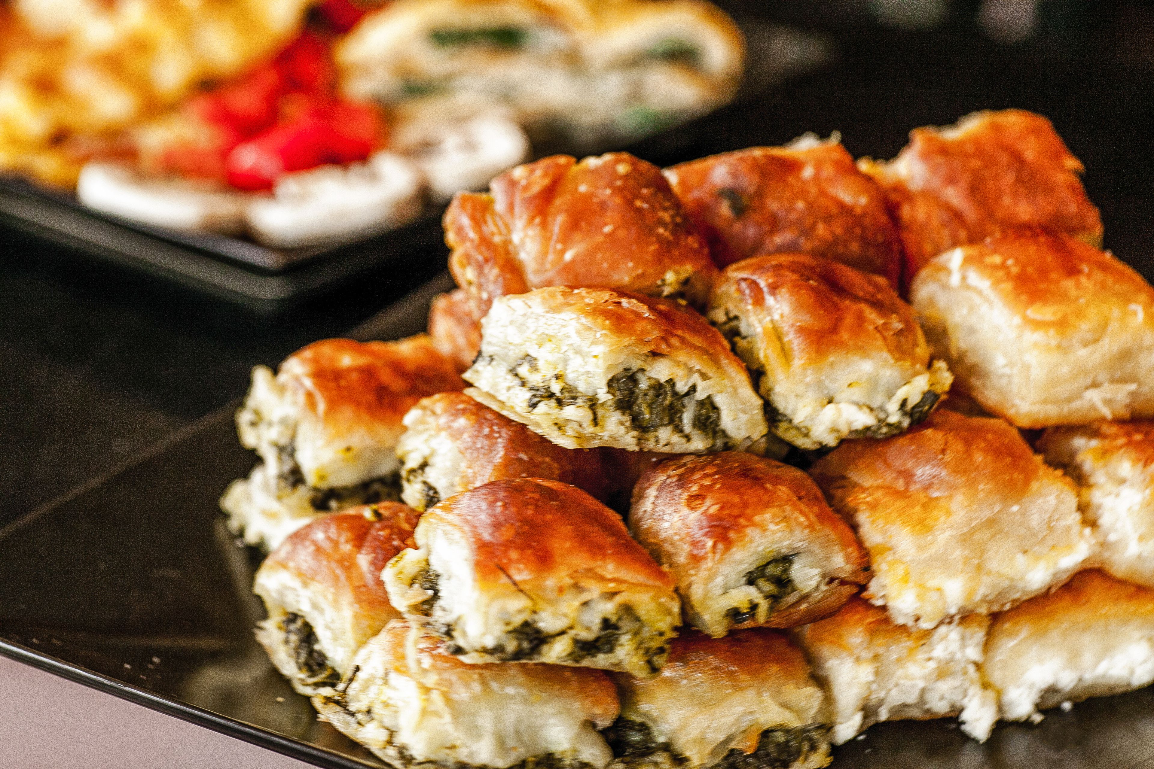 Une assiette de viennoiseries dorées, avec une garniture verte bien visible, ce qui laisse supposer un goût savoureux.