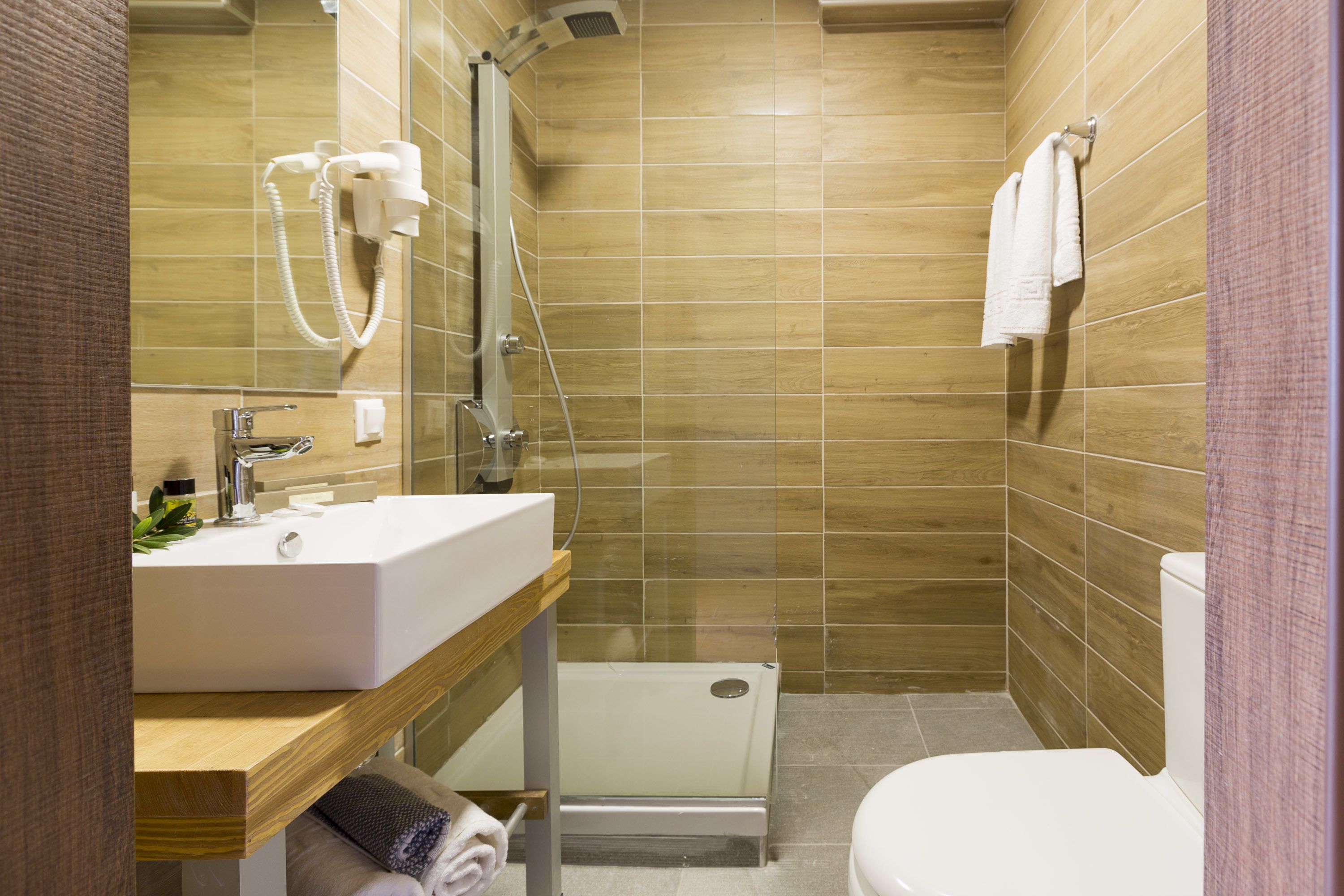 Un baño moderno con ducha, inodoro y lavamanos.