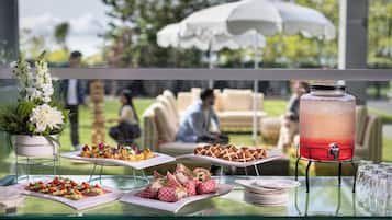 A buffet table with various food items and a large beverage dispenser.