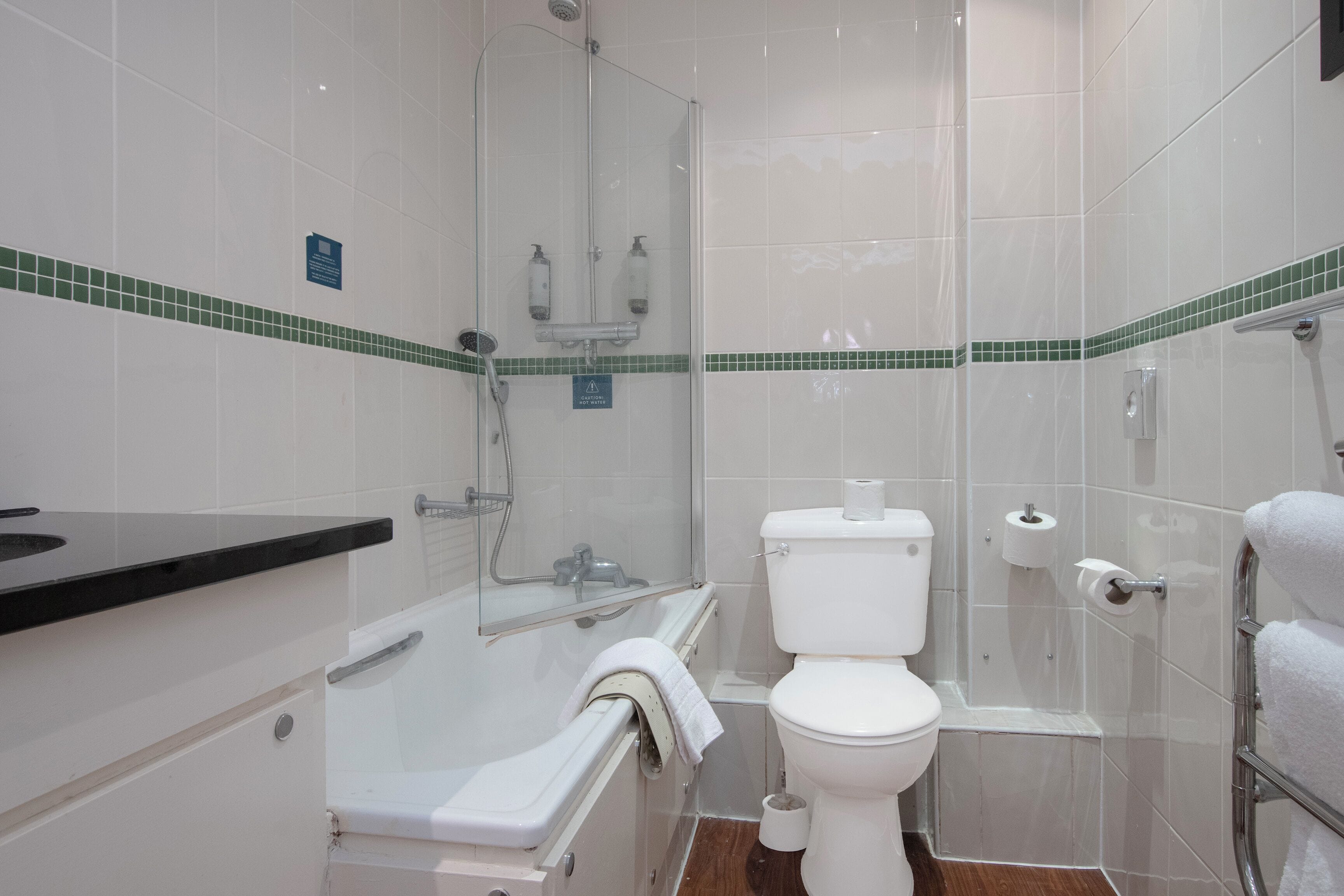 Un baño con bañera, inodoro y ducha.
