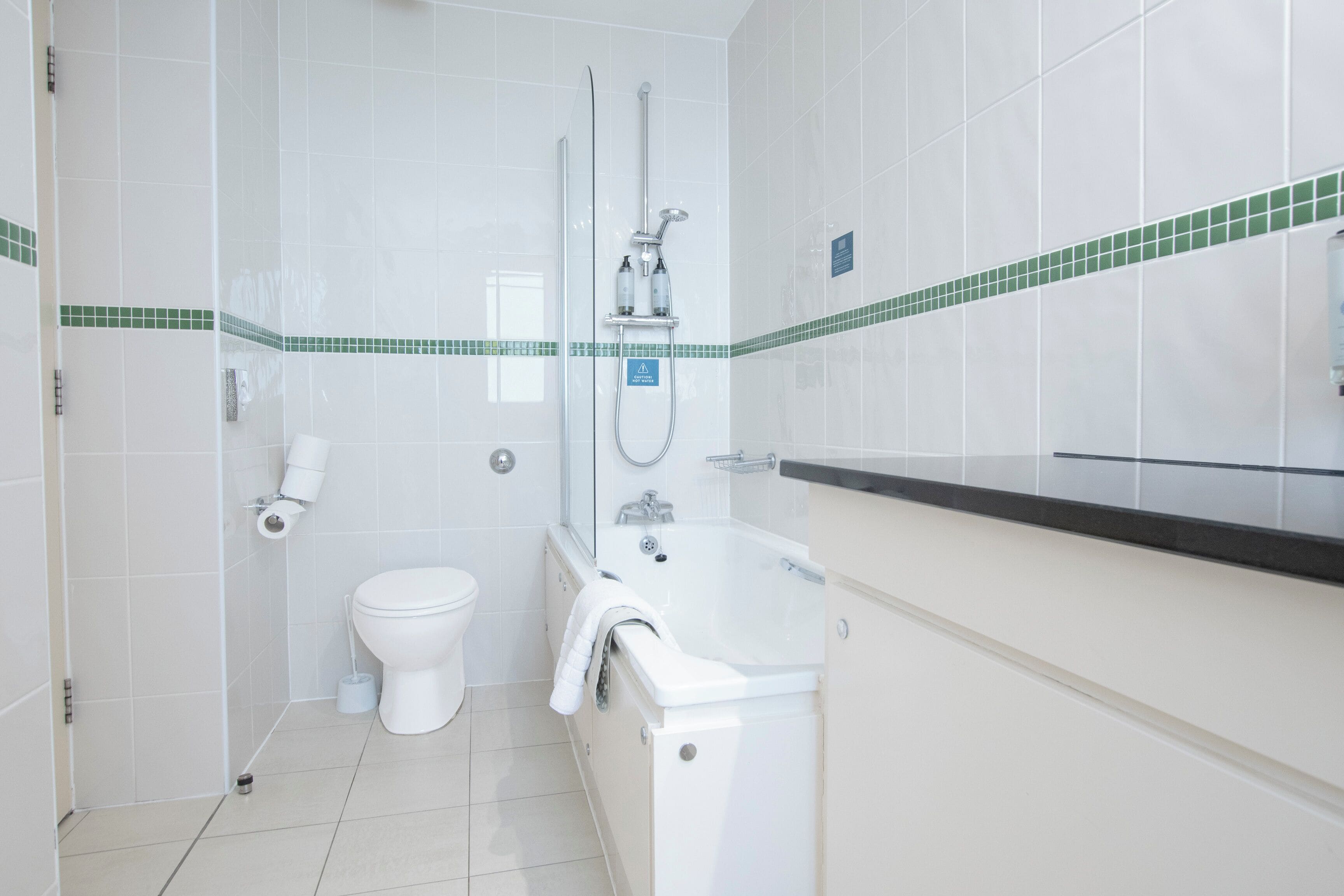 Un baño con inodoro, ducha y lavamanos.