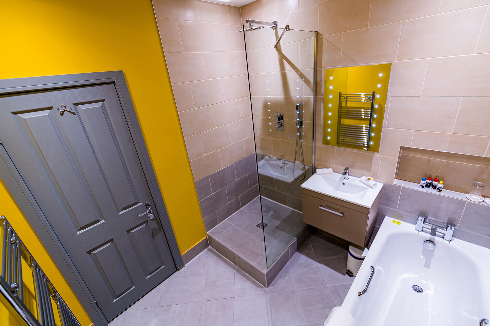 A modern bathroom with a glass-enclosed shower, a vanity with a sink, and a bathtub.