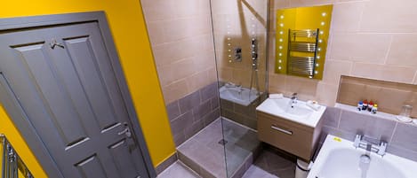 A modern bathroom with a glass-enclosed shower, a vanity with a sink, and a bathtub.