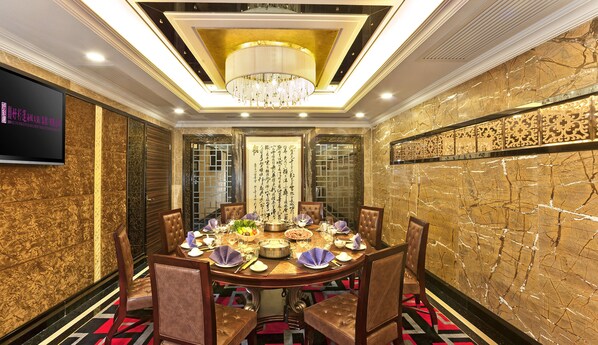 A formal dining room with a round table, chairs, and a chandelier. - HOTEL EMPEROR - MACAU (Macau)