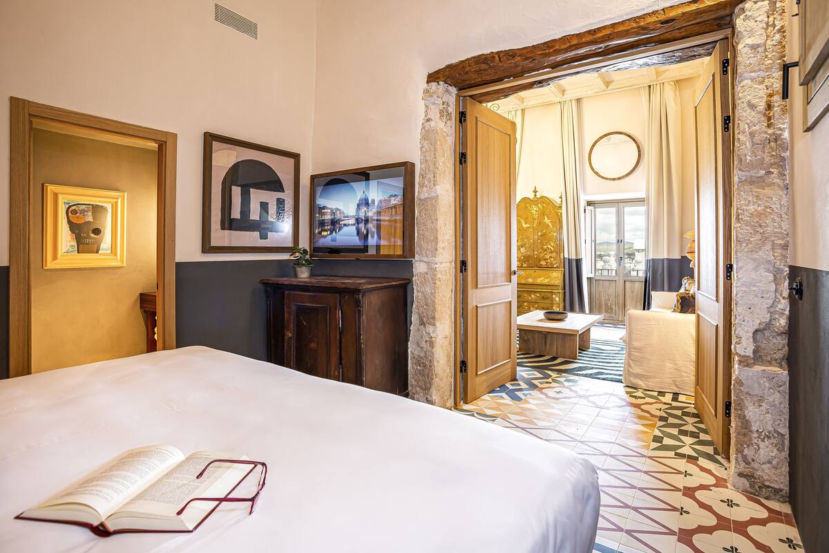 Ein Hotelzimmer mit Bett, Schreibtisch, Fernseher und Blick ins Freie.