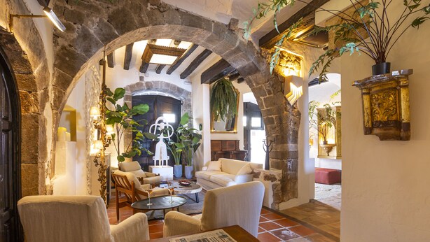 Un interior acogedor con arcos de piedra, chimenea y asientos cómodos.