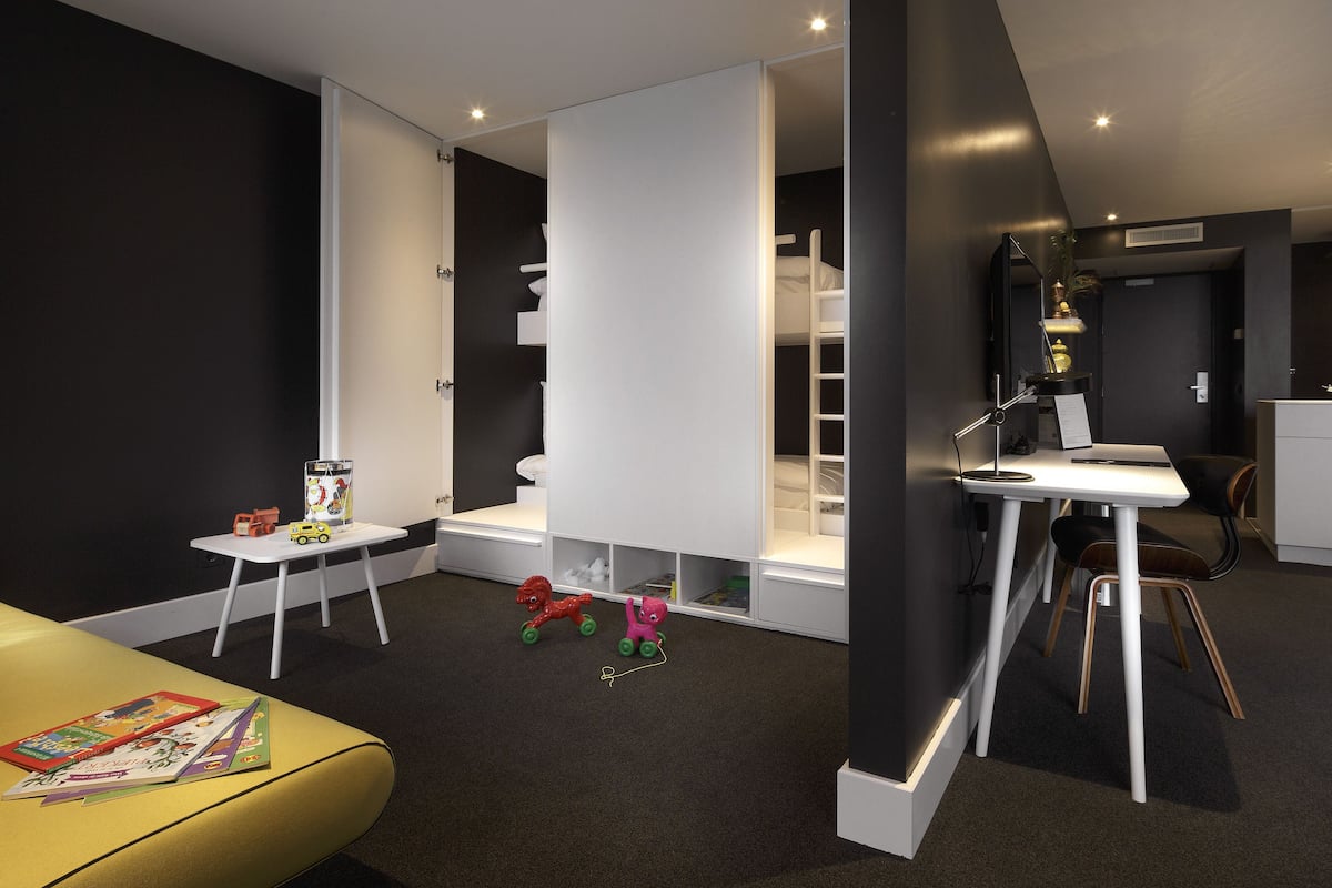 Una habitación moderna y bien iluminada con un escritorio, una silla y una pequeña mesa con juguetes.