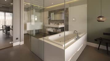 Een moderne badkamer met een glazen douchecabine, een vrijstaand bad en een wastafel met spiegel.