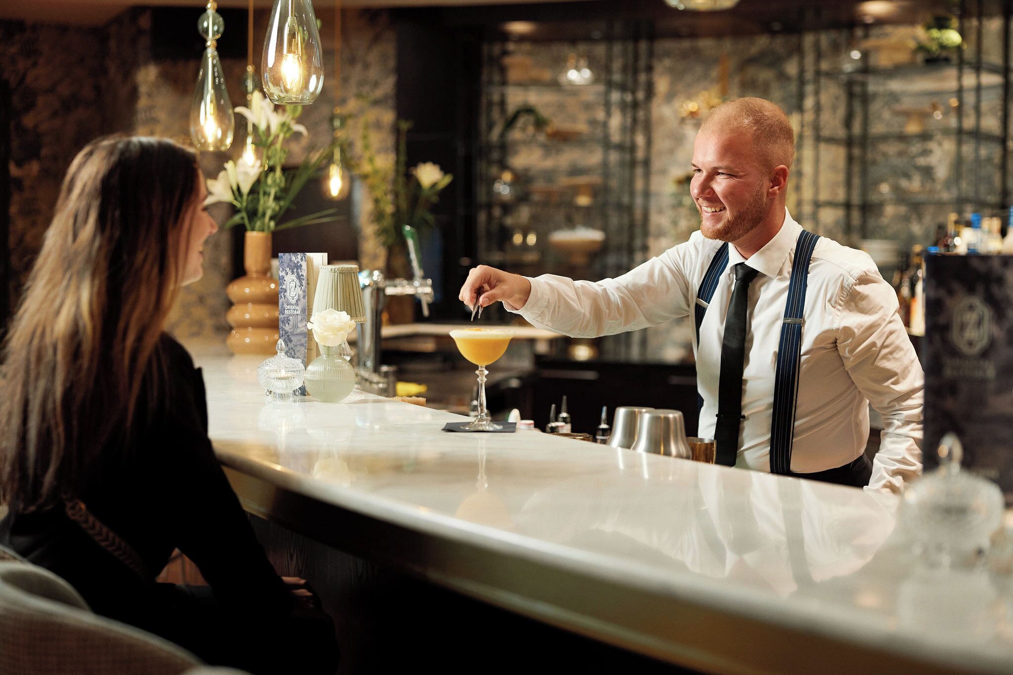 A bar area with a bartender serving a drink.