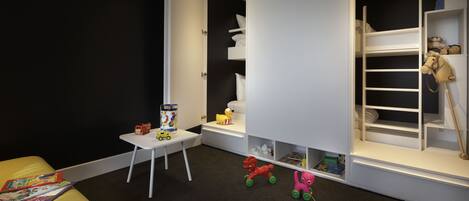 A child's room with a bunk bed, a small table, and toys.
