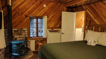 Una habitación acogedora con cama, chimenea, ventana y puerta.