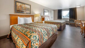 A hotel room with two beds, a desk, and a chair. - Rodeway Inn Albany (Albany)