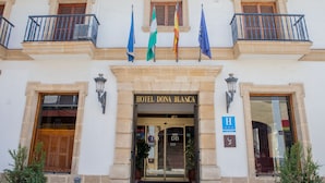 L’entrée de l’hôtel Dona Blanca offre une vue dégagée sur la façade, notamment sur l’enseigne et les portes d’entrée.
