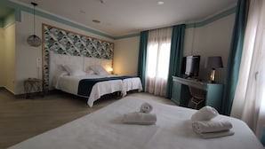 Une chambre d’hôtel avec un lit, un bureau doté d’une télévision et une chaise.