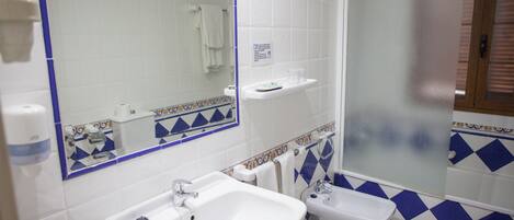 A bathroom with a sink, toilet, and shower.