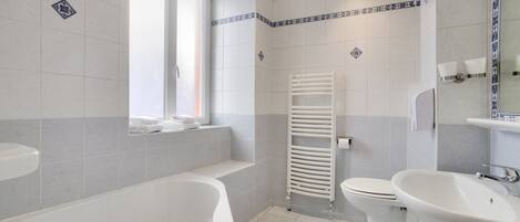 A modern bathroom with a bathtub, toilet, and sink.