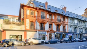 Une rangée de bâtiments de style européen, comprenant un hôtel, une école de musique et un restaurant.