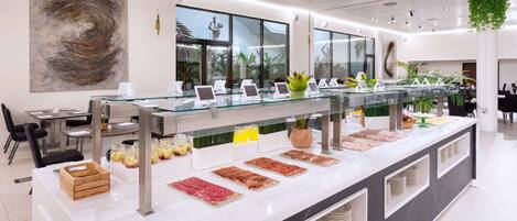A modern breakfast bar with a variety of food items and a large abstract painting on the wall.