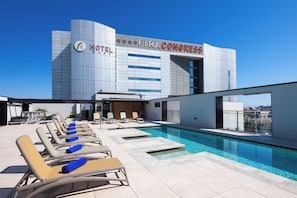 A hotel with a rooftop pool, lounge chairs, and a view of the city. - Alexandre Fira Congress (L'Hospitalet de Llobregat)